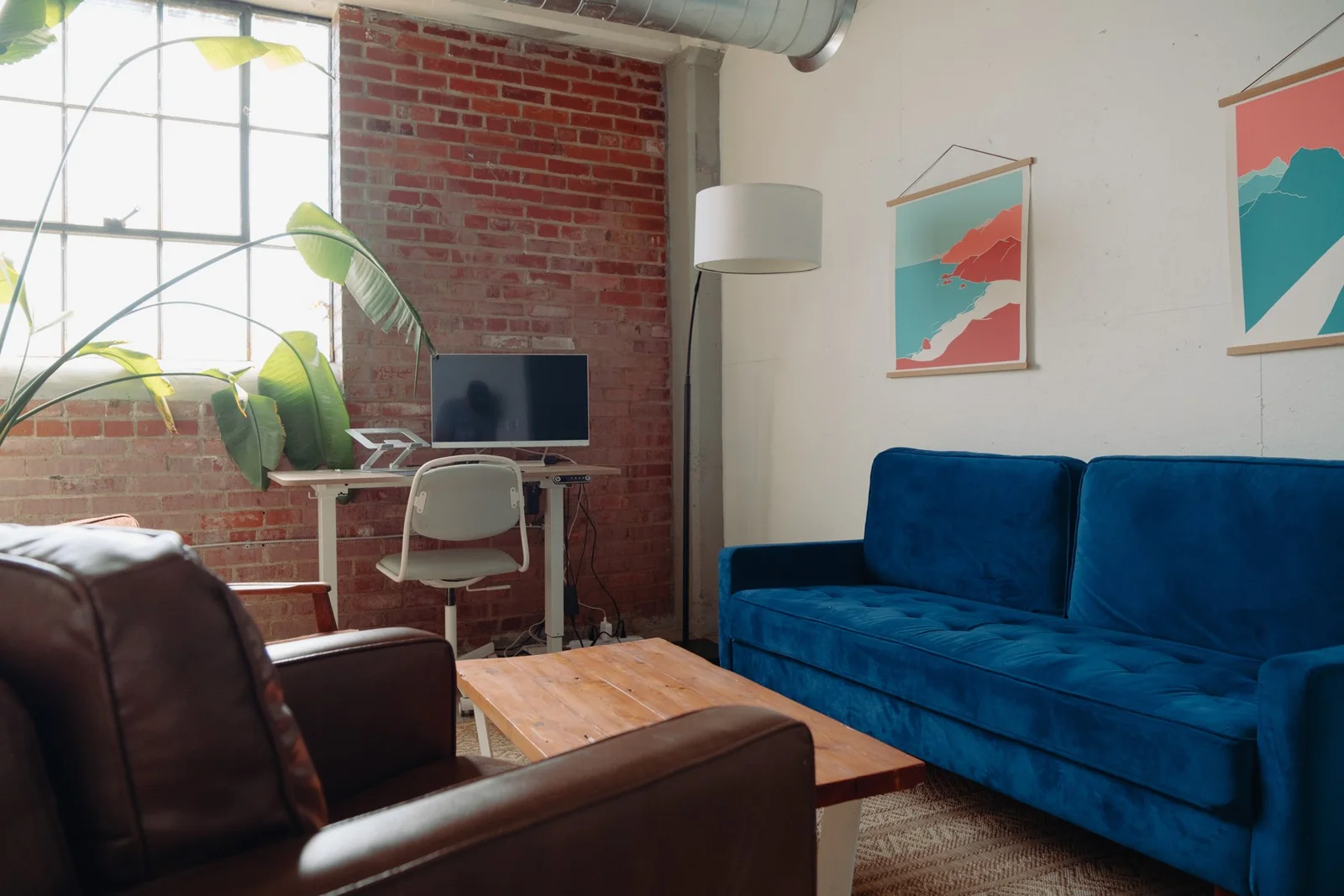 A blue velvet sofa in a brick loft