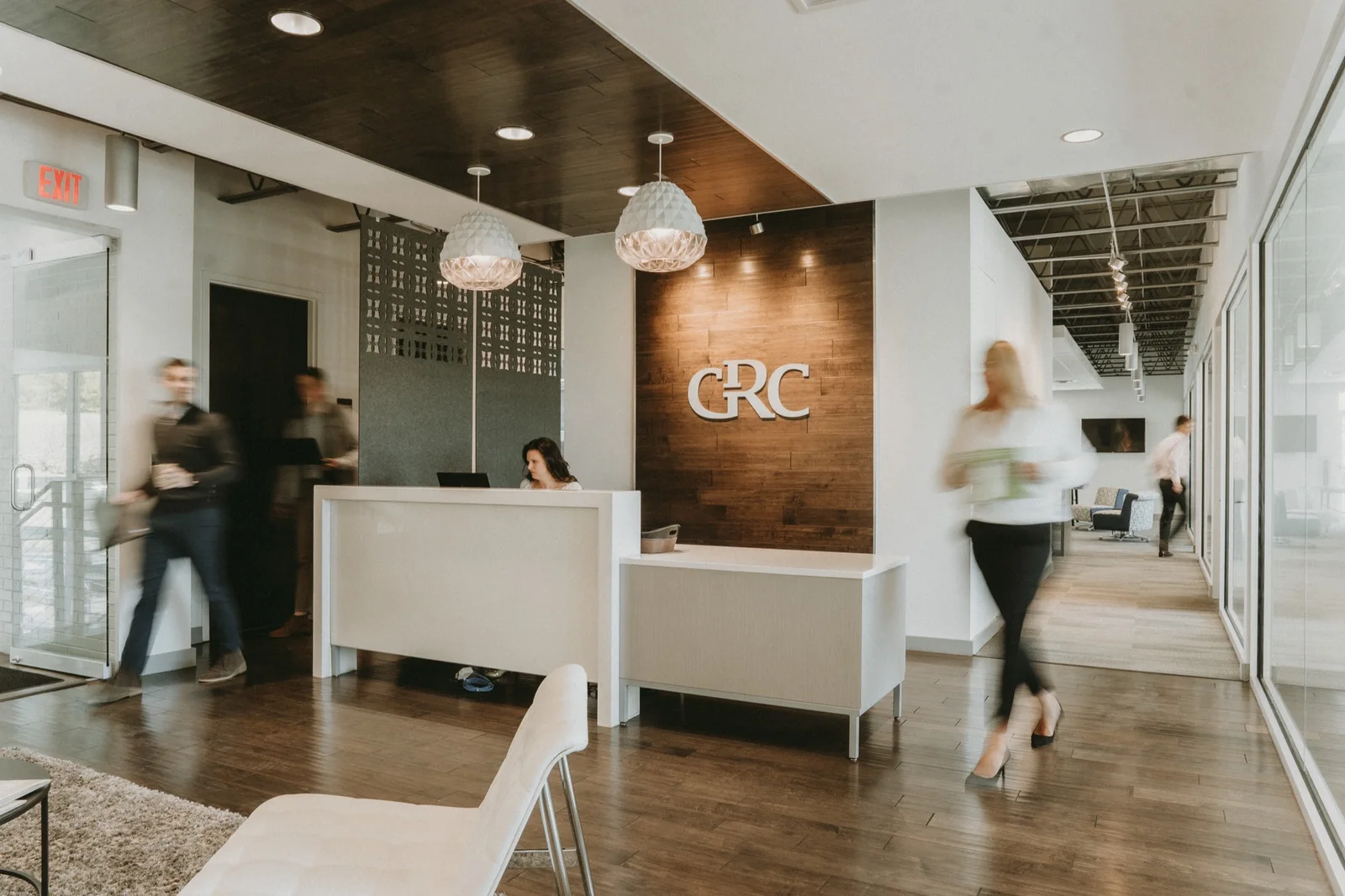 A welcome desk with people moving through a workplace