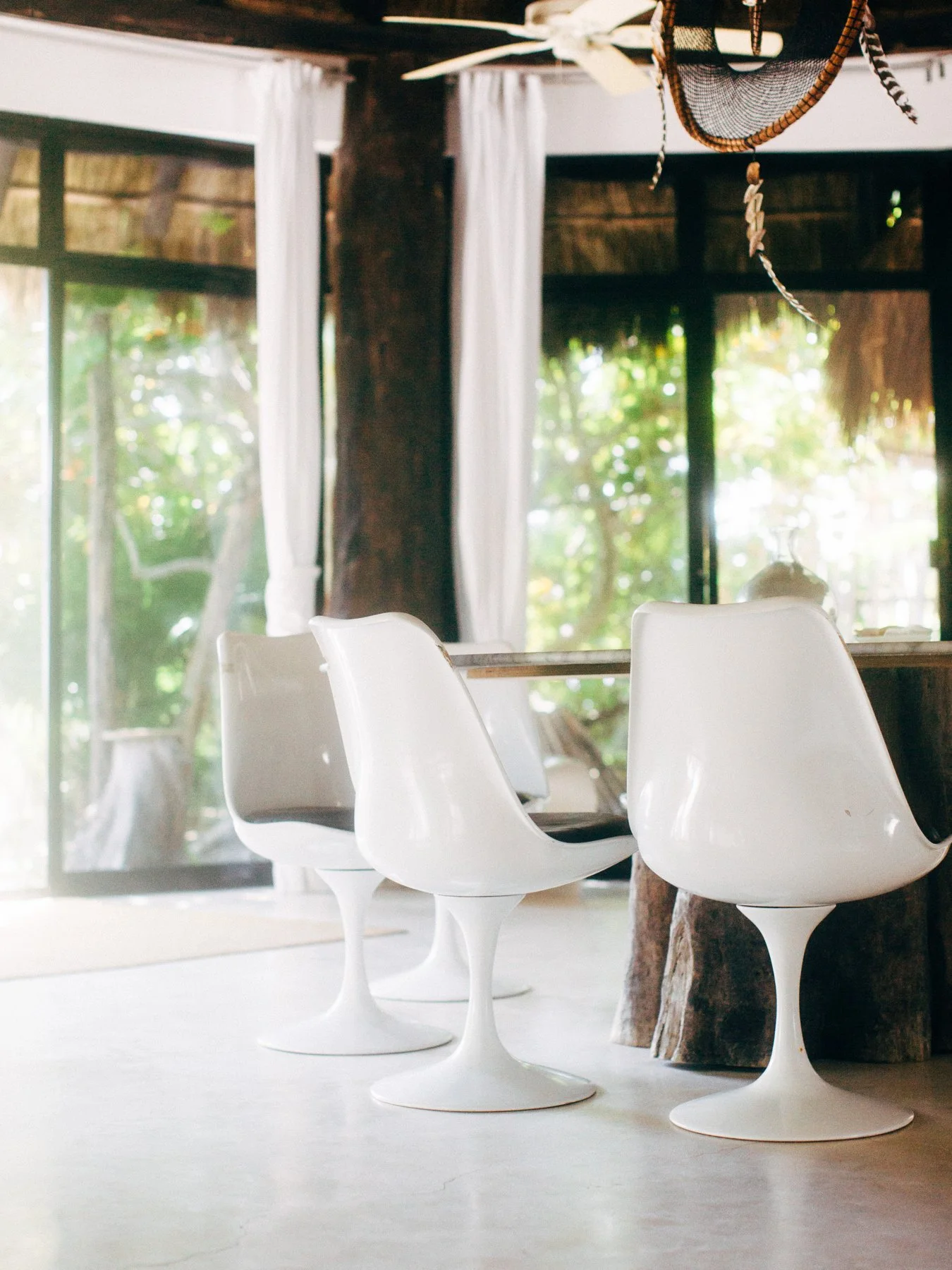 White sculptural chairs and pendant lighting
