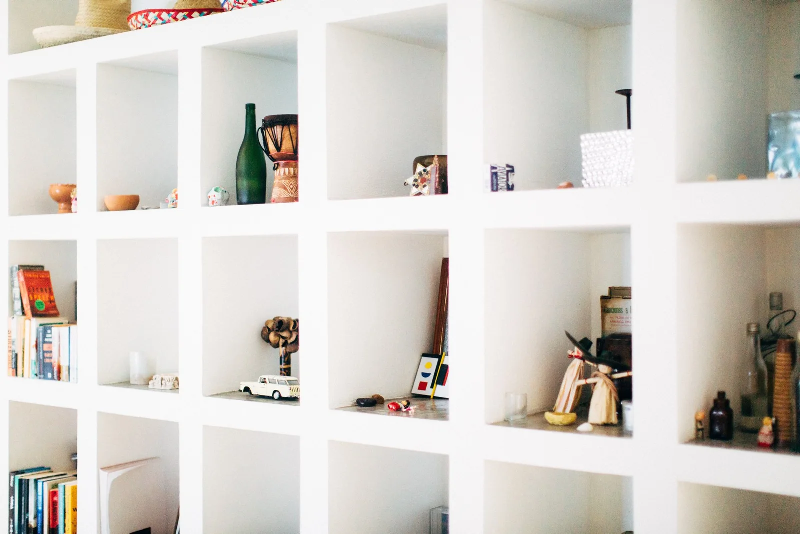 Objects and books arranged on white shelves